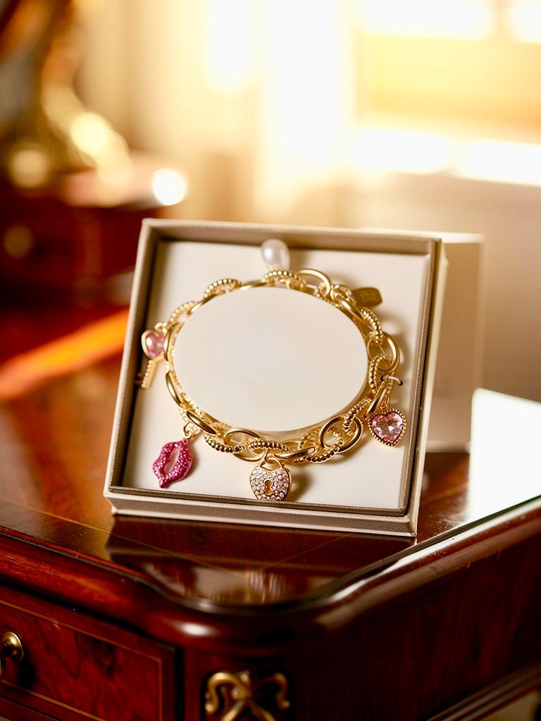 Gold Tone and Pink Charm Bracelet - Reed House of Jewels