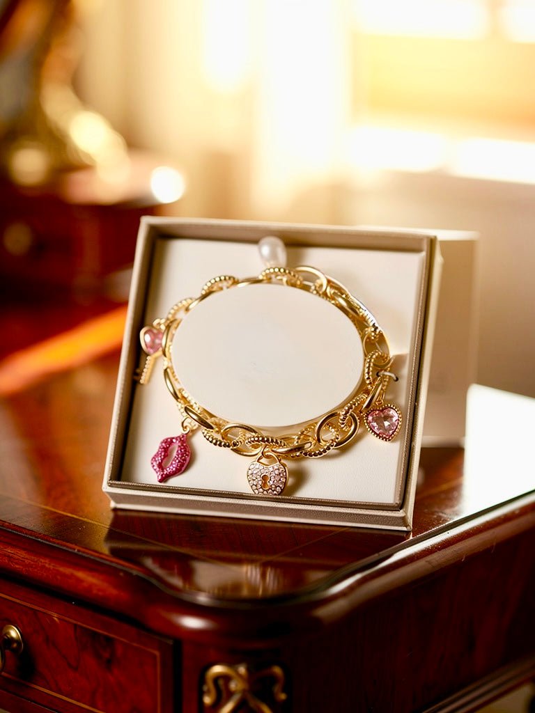 Gold Tone and Pink Charm Bracelet - Reed House of Jewels