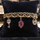 Gold Tone and Pink Charm Bracelet - Reed House of Jewels